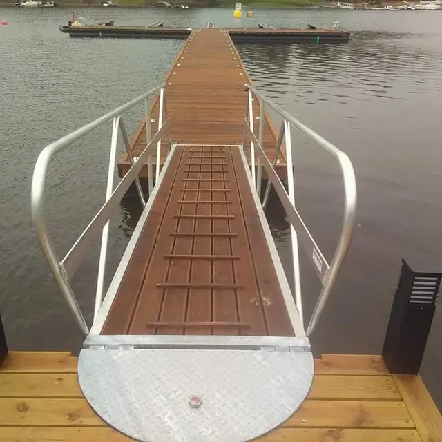 run landgang i metallramme kobler brygge til flytebrygge i småbåthavn.